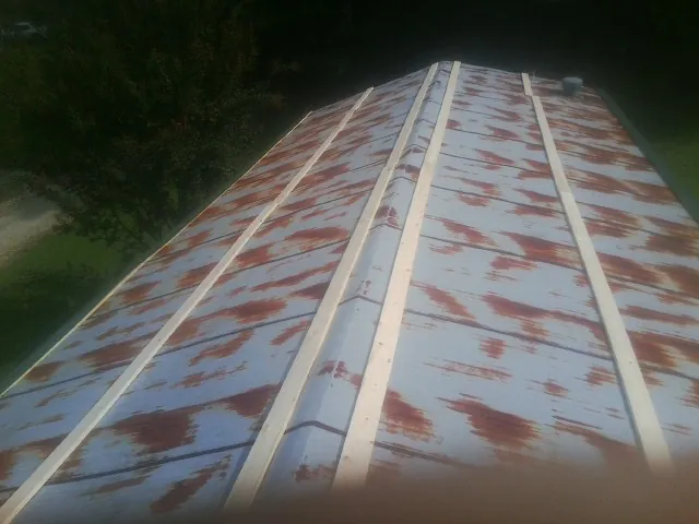 Rusted metal roof panels with new wood purlins before replacement — Storm Damage Roof Repair in Sidney Center by Roofing Brothers