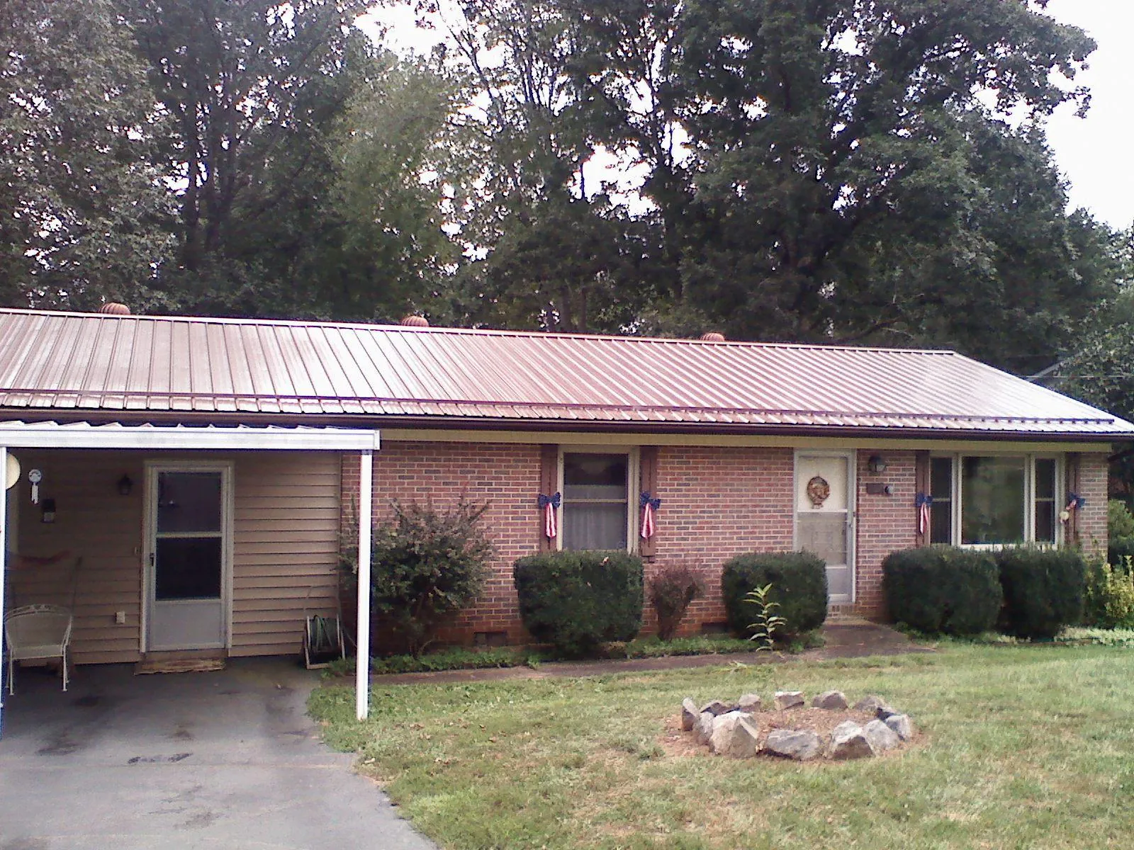 Bronze metal roof and carport on a brick ranch home — Roof Repair work by our crew in Sidney Center